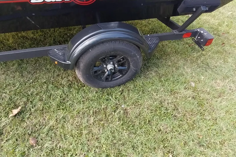 Slide: The Image of 2023 Tracker Bass Tracker Classic XL trailer wheel on grass. - 4