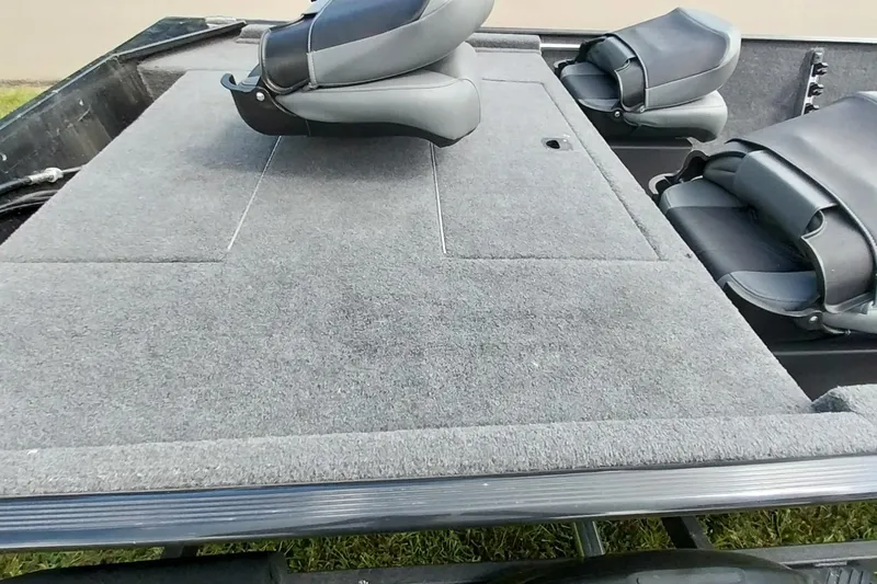 Slide: The Image of 2023 Tracker Bass Tracker Classic XL boat interior with gray carpet and seating. - 9