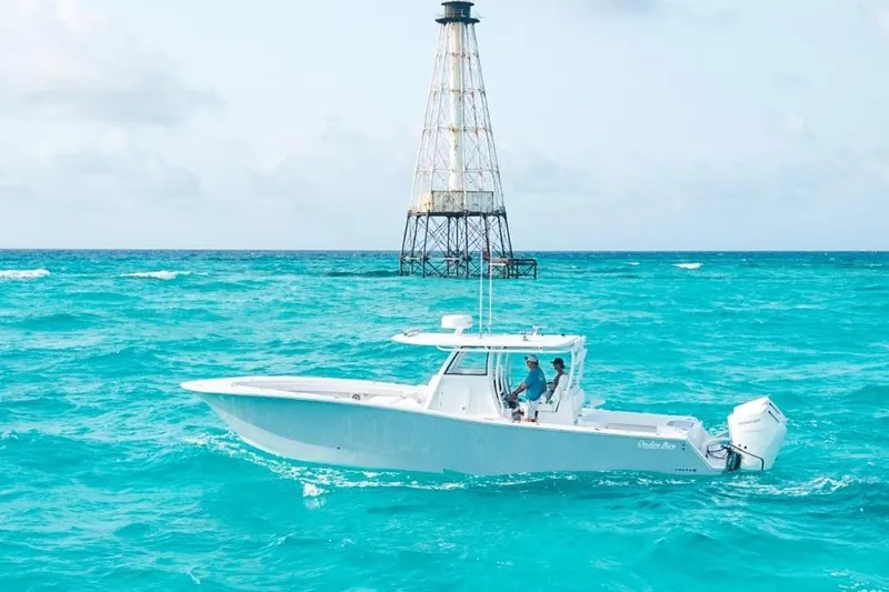 Slide: The Image of 2024 Onslow Bay 37 Offshore boat cruising near a lighthouse in turquoise waters. - 4