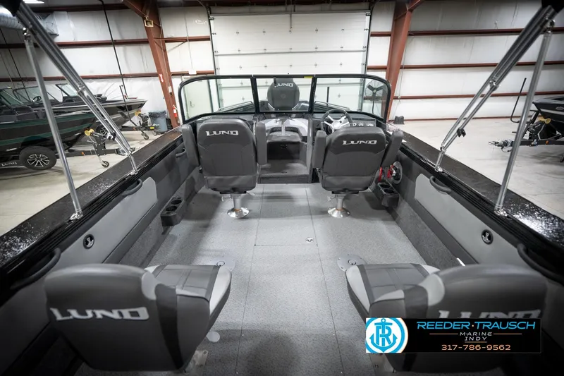 Slide: The Image of Interior of 2026 Lund 2275 Baron boat with seating and steering wheel in a showroom. - 16