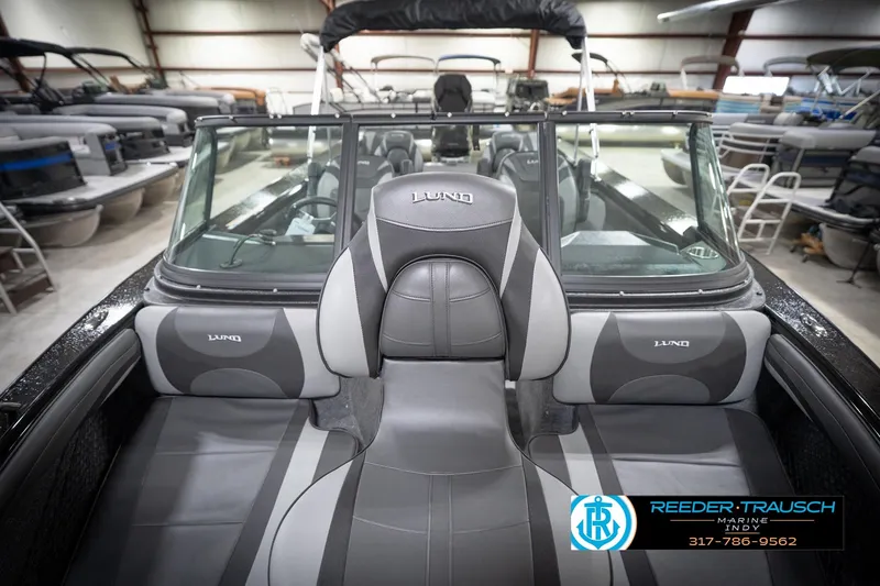 Slide: The Image of 2026 Lund 2275 Baron boat interior with gray seating in showroom. - 19