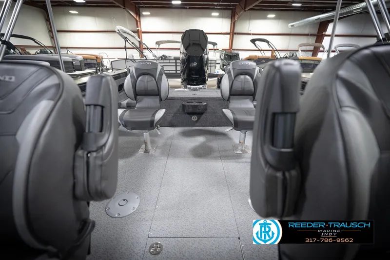 Slide: The Image of 2026 Lund 2275 Baron boat interior with gray seating in a showroom. - 20