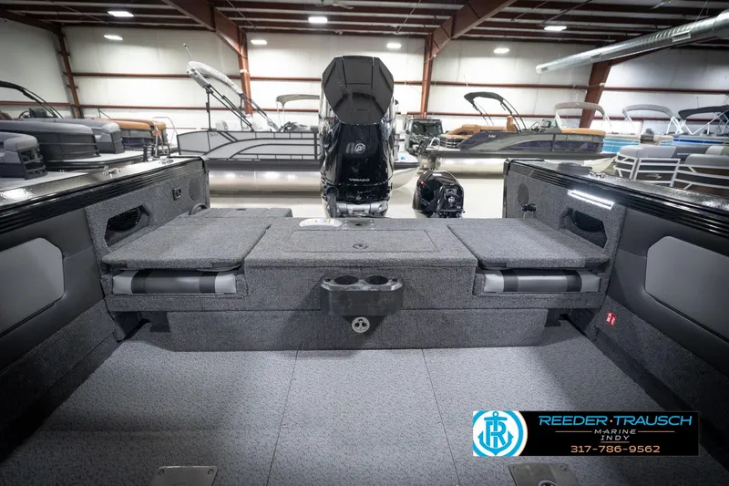 Slide: The Image of 2026 Lund 2275 Baron boat interior with seating and motor in showroom. - 23