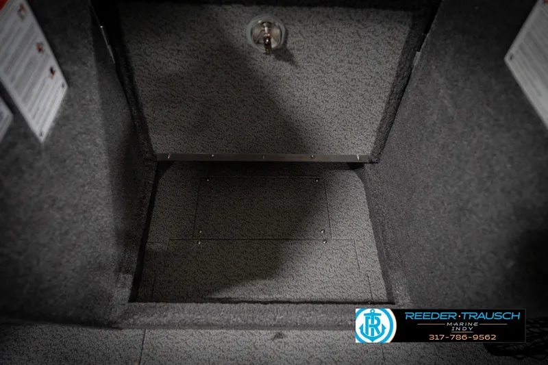 Slide: The Image of Interior storage compartment of 2026 Lund 2275 Baron boat, featuring carpeted finish. - 30