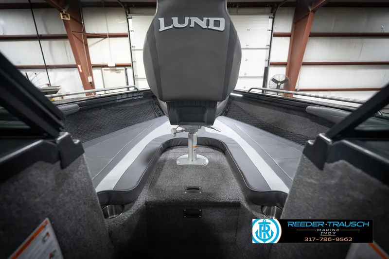 Slide: The Image of 2026 Lund 2275 Baron boat interior with seating and logo, displayed in a showroom. - 31