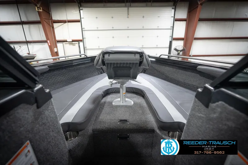 Slide: The Image of 2026 Lund 2275 Baron boat interior with seating and steering, showcased in a showroom. - 32