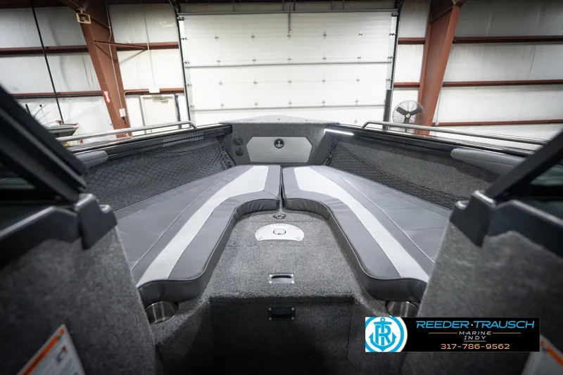 Slide: The Image of 2026 Lund 2275 Baron boat interior with gray seating in a garage setting. - 33
