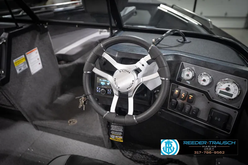 Slide: The Image of Steering wheel and dashboard of 2026 Lund 2275 Baron boat, featuring gauges and controls. - 35