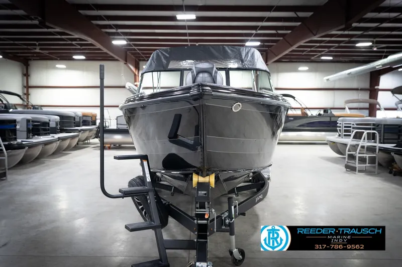 Slide: The Image of 2026 Lund 2275 Baron boat in showroom, front view, on trailer, Reeder-Trausch Marine logo visible. - 5