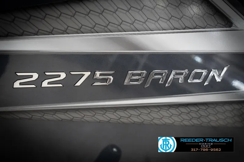 Slide: The Image of 2026 Lund 2275 Baron boat emblem with textured background and Reeder-Trausch Marine logo. - 64