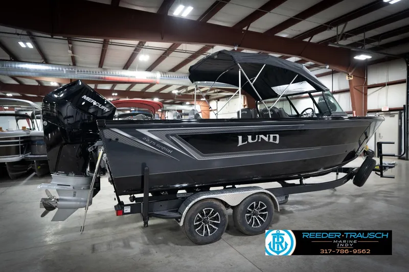 Slide: The Image of 2026 Lund 2275 Baron boat in showroom, featuring Mercury engine and sleek black design. - 8