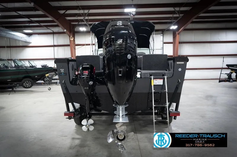 Slide: The Image of 2026 Lund 2275 Baron boat in showroom, rear view with outboard motor. - 9