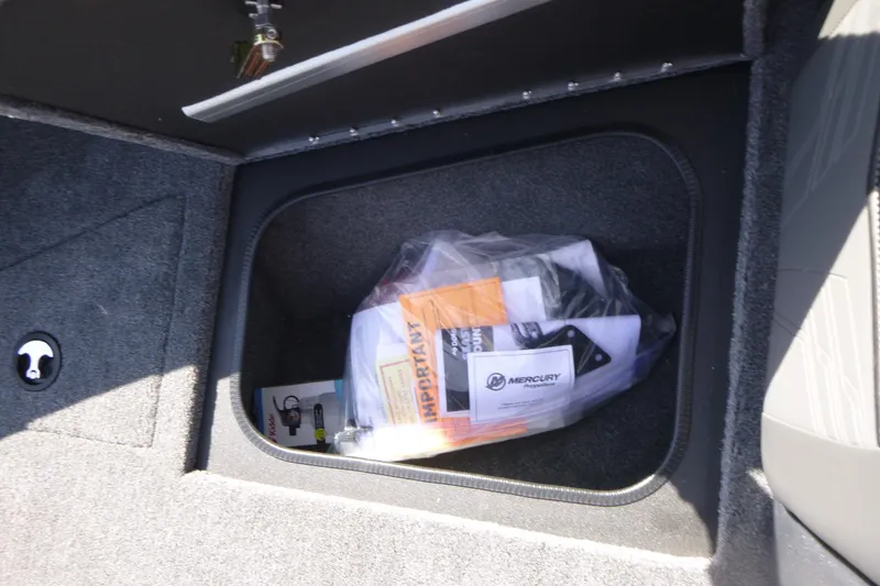 Slide: The Image of Storage compartment in 2026 Tracker Targa V-19 WT boat with manuals and accessories. - 10
