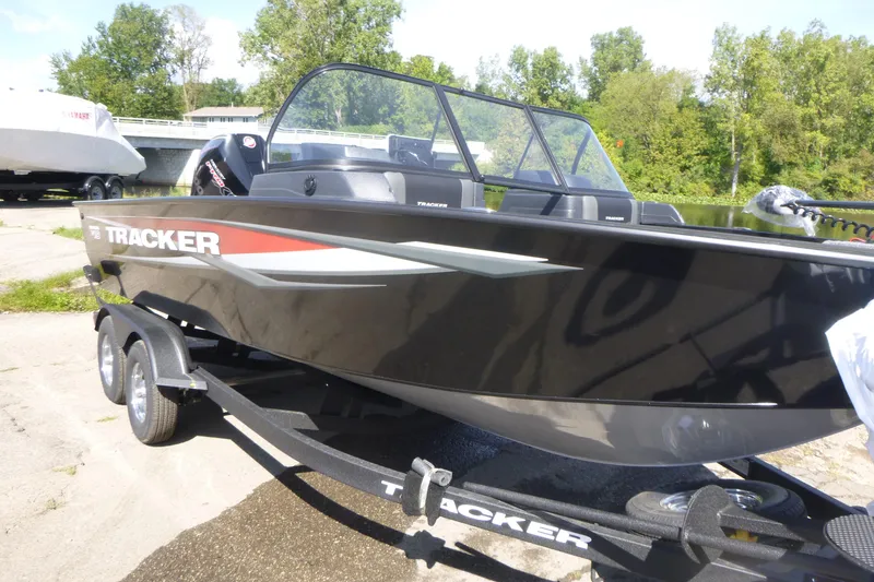 Slide: The Image of 2026 Tracker Targa V-19 WT boat on trailer by a riverbank. - 3