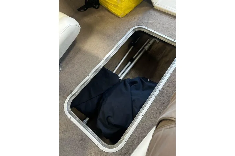 Slide: The Image of Storage compartment in 2013 Stingray 195RX boat with folded items and equipment. - 10