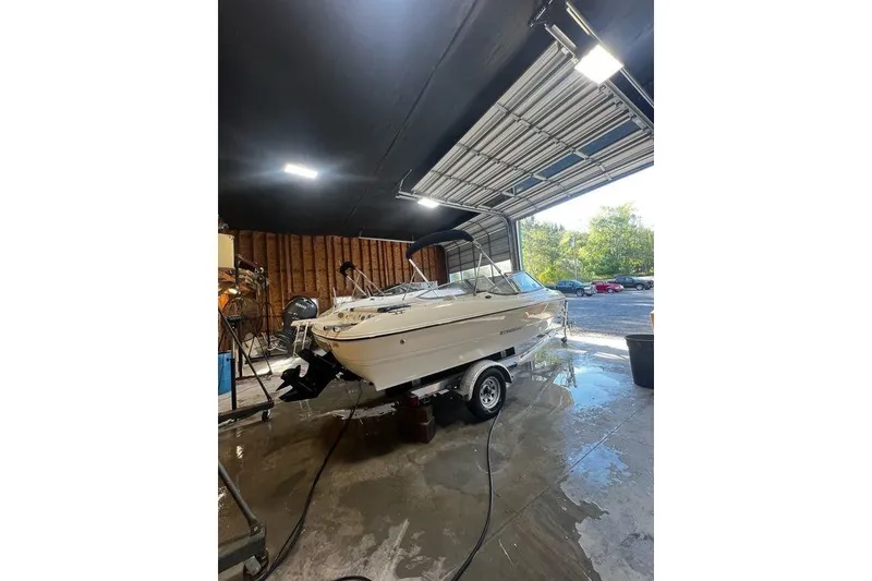 Slide: The Image of 2013 Stingray 195RX boat in a garage, ready for maintenance or storage. - 12