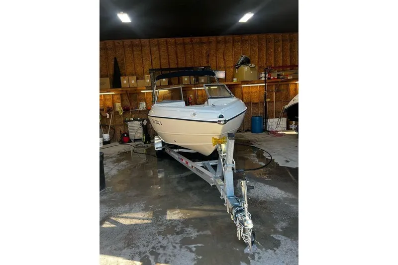 Slide: The Image of 2013 Stingray 195RX boat on trailer in a garage setting. - 13