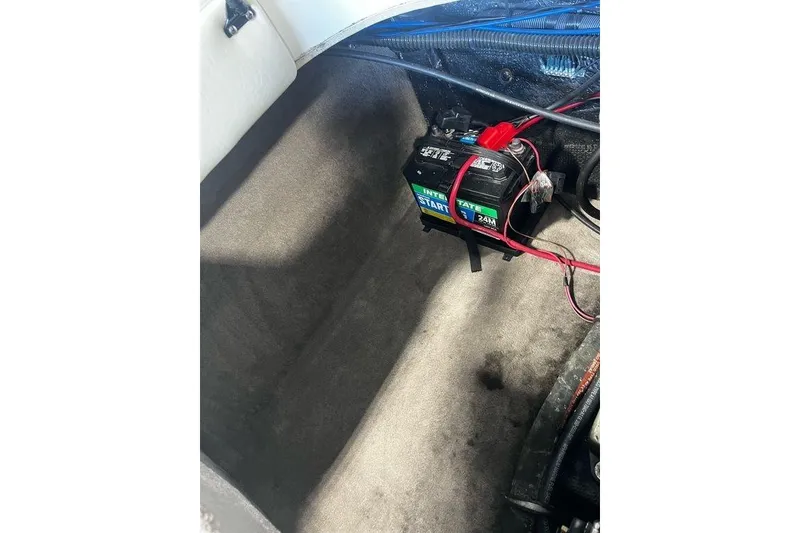 Slide: The Image of 2013 Stingray 195RX boat battery compartment with Interstate battery and wiring. - 15