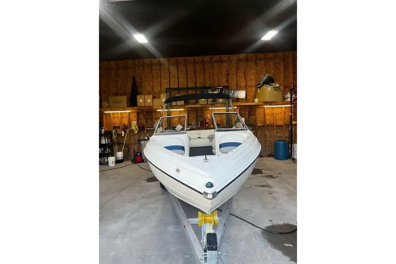 Slide: The Image of 2013 Stingray 195RX boat in a garage, showcasing sleek design and white exterior. - 18