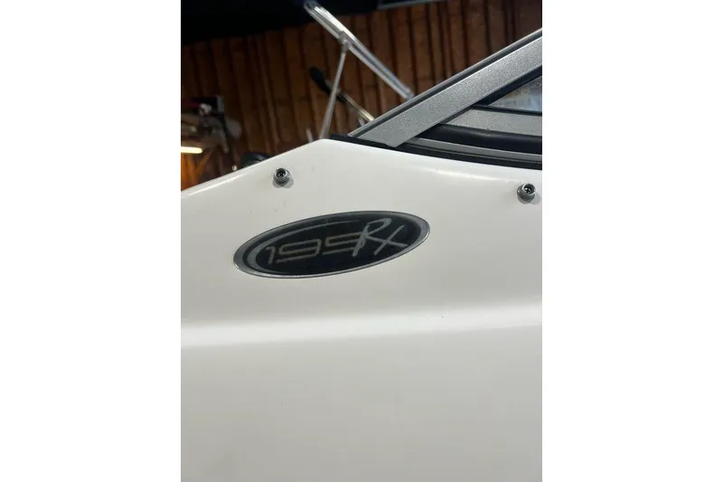 Slide: The Image of 2013 Stingray 195RX boat emblem on white surface in a garage setting. - 19