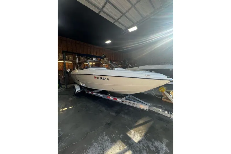 Slide: The Image of 2013 Stingray 195RX boat on trailer in a garage setting. - 21