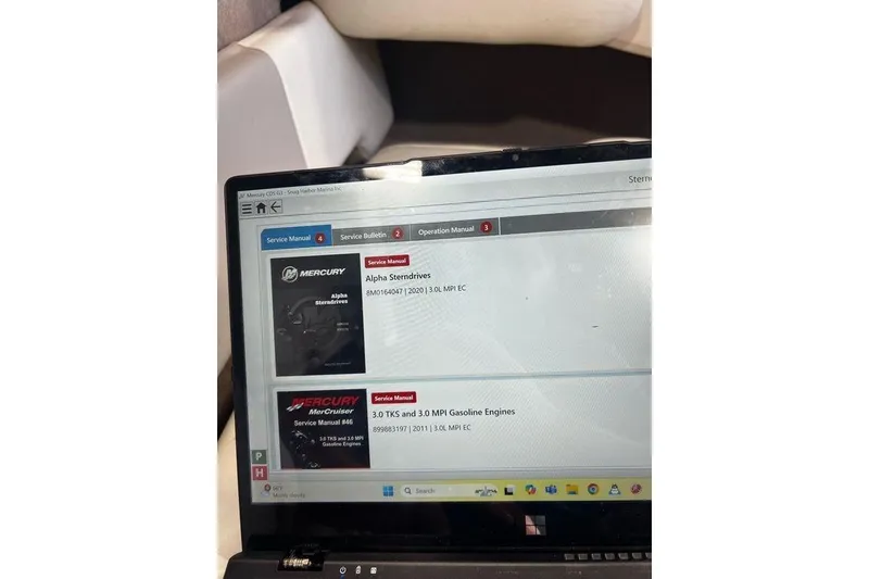 Slide: The Image of Laptop displaying service manuals for Mercury Alpha Sterndrives and MerCruiser engines. - 24