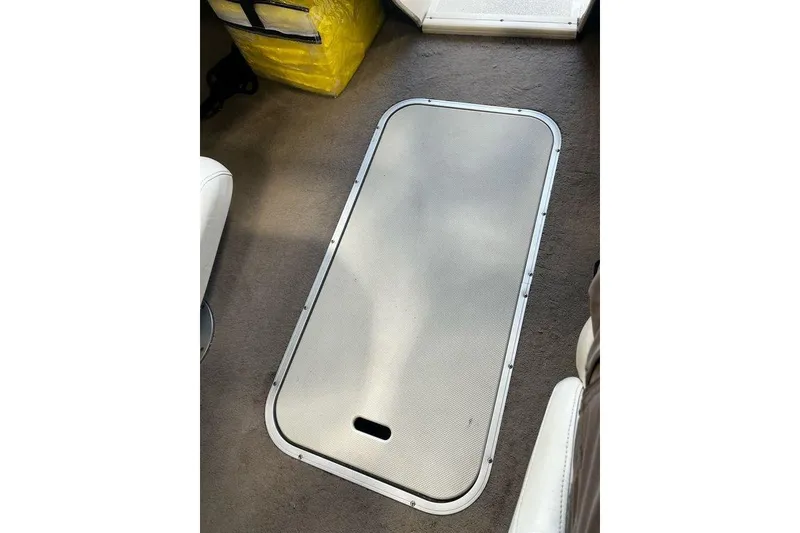 Slide: The Image of 2013 Stingray 195RX boat interior with storage compartment on carpeted floor. - 4