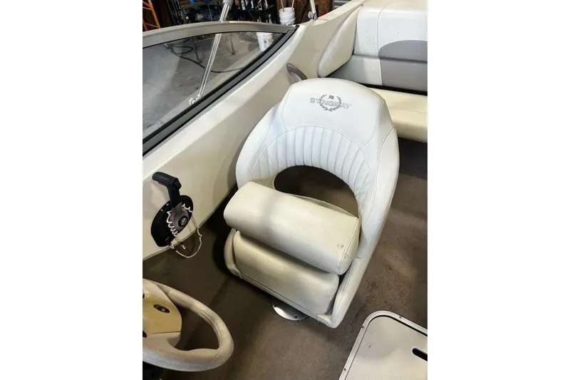 Slide: The Image of 2013 Stingray 195RX boat interior with white captain's chair and steering controls. - 9