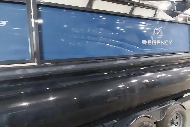 Slide: The Image of 2022 Regency 250 DL3 pontoon boat with sleek blue and black design. - 19
