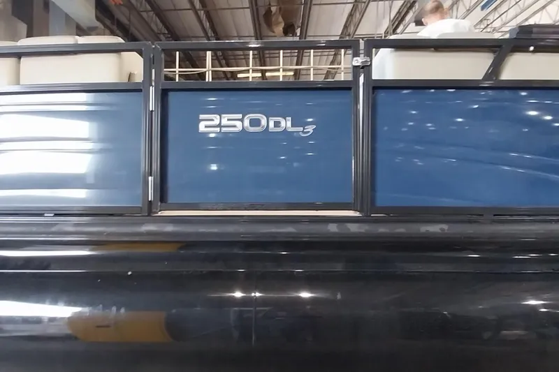 Slide: The Image of 2022 Regency 250 DL3 pontoon boat in a warehouse setting. - 20