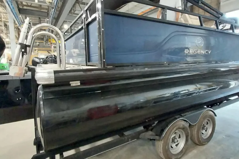 Slide: The Image of 2022 Regency 250 DL3 pontoon boat on trailer in industrial setting. - 22