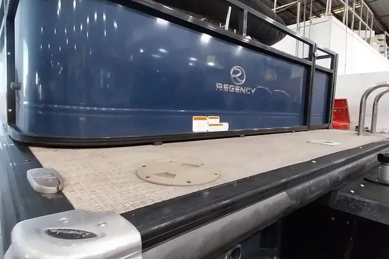 Slide: The Image of 2022 Regency 250 DL3 pontoon boat, blue exterior, docked indoors. - 23