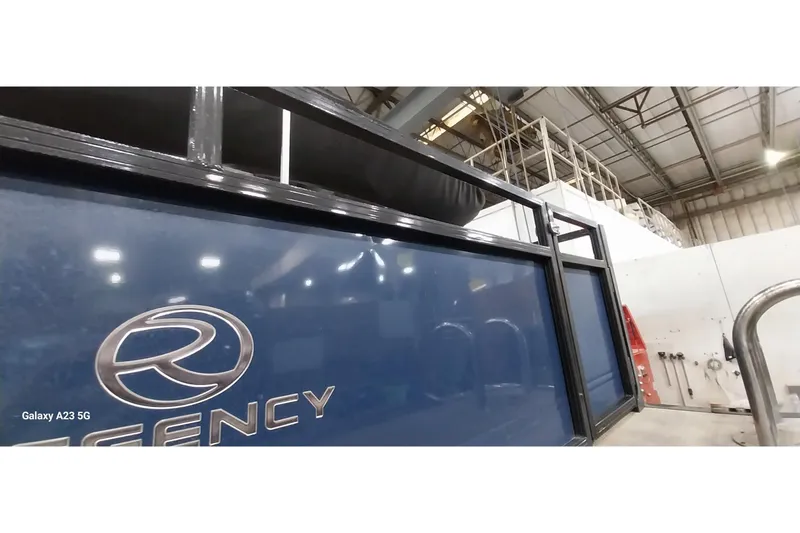 Slide: The Image of 2022 Regency 250 DL3 boat in a warehouse, showcasing sleek blue exterior design. - 24