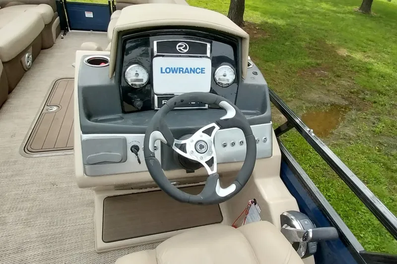 Slide: The Image of 2022 Regency 250 DL3 boat dashboard with steering wheel and Lowrance display. - 5