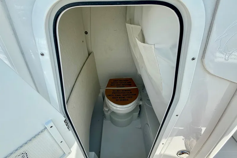 Slide: The Image of 2026 Sea Hunt Ultra 245 SE boat interior with compact marine toilet. - 13