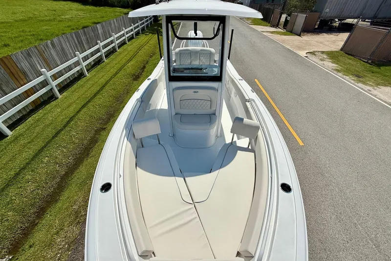 Slide: The Image of 2026 Sea Hunt Ultra 245 SE boat on road, showcasing spacious deck and seating. - 16