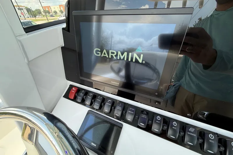 Slide: The Image of 2026 Sea Hunt Ultra 245 SE dashboard with Garmin display and control switches. - 17