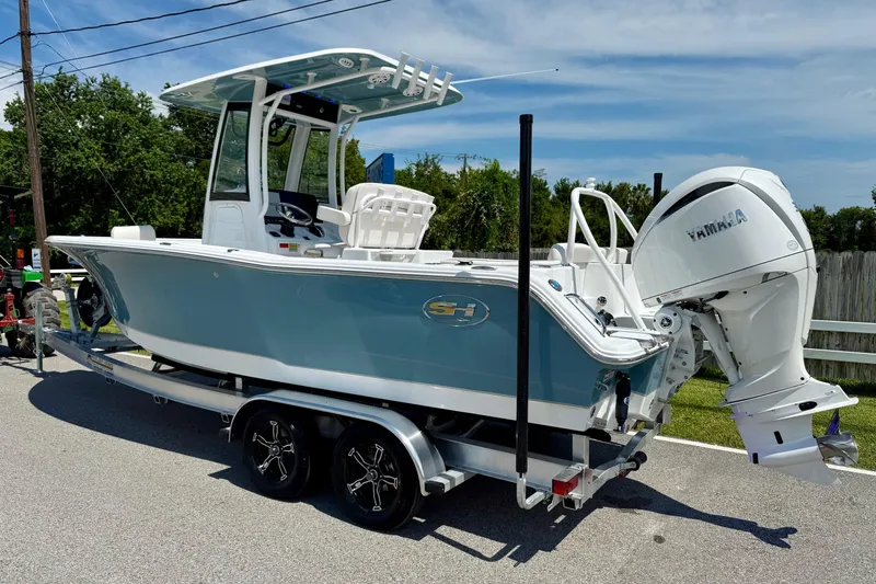 Slide: The Image of 2026 Sea Hunt Ultra 245 SE boat on trailer with Yamaha engine, parked outdoors. - 2