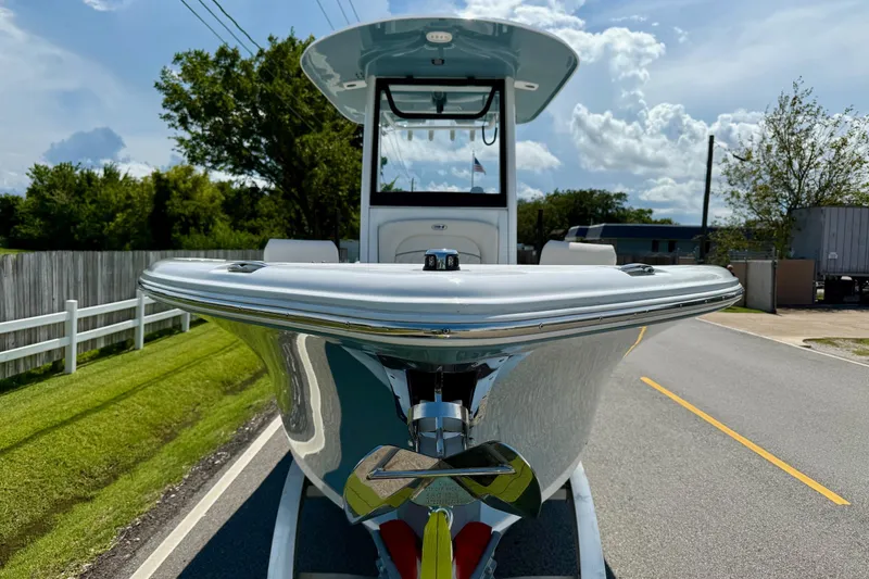 Slide: The Image of 2026 Sea Hunt Ultra 245 SE boat on trailer, parked on a sunny road. - 6