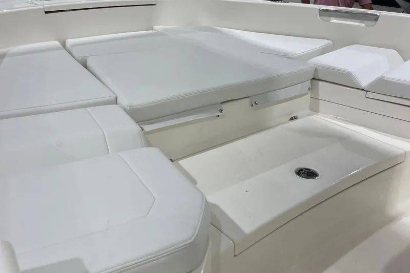 Slide: The Image of 2026 Pathfinder 2400 TRS boat interior with white cushioned seating and storage area. - 24