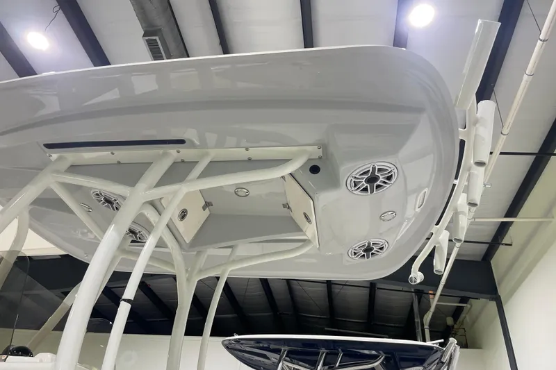 Slide: The Image of 2026 Pathfinder 2400 TRS boat T-top with speakers and rod holders in a showroom. - 29