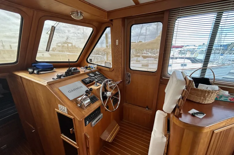 Slide: The Image of 2004 Sabre 36 FB boat interior with wooden helm, steering wheel, and Garmin navigation system. - 24
