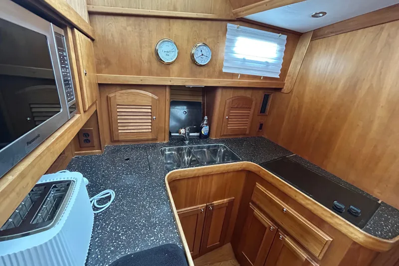 Slide: The Image of 2004 Sabre 36 FB yacht kitchen with wooden cabinetry, sink, and appliances. - 30