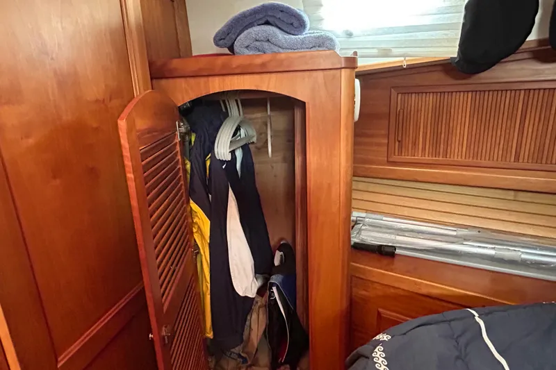 Slide: The Image of Wooden closet with hanging clothes inside a 2004 Sabre 36 FB boat interior. - 31