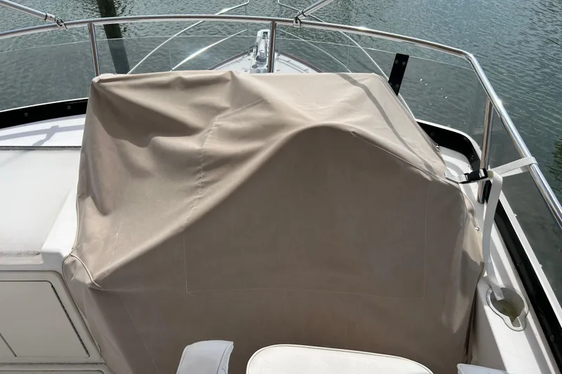 Slide: The Image of Covered helm station on a 2004 Sabre 36 FB boat, docked by the water. - 8