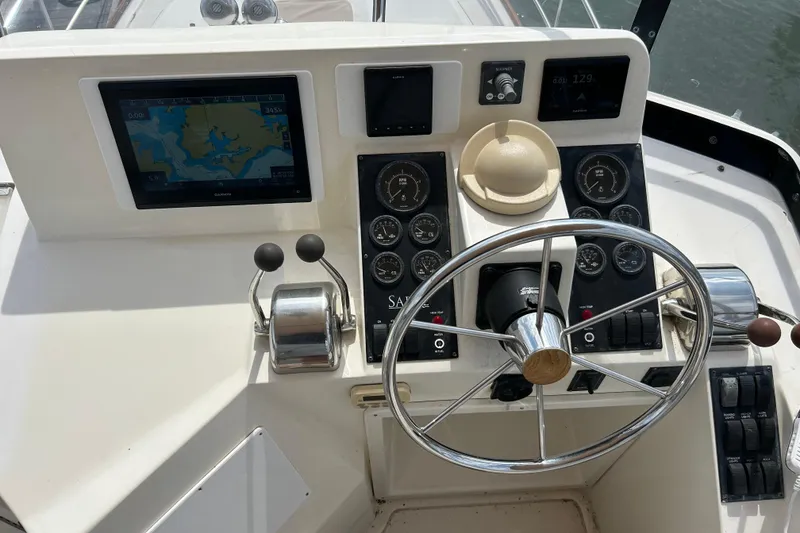 Slide: The Image of 2004 Sabre 36 FB boat helm with navigation screen and steering wheel. - 13