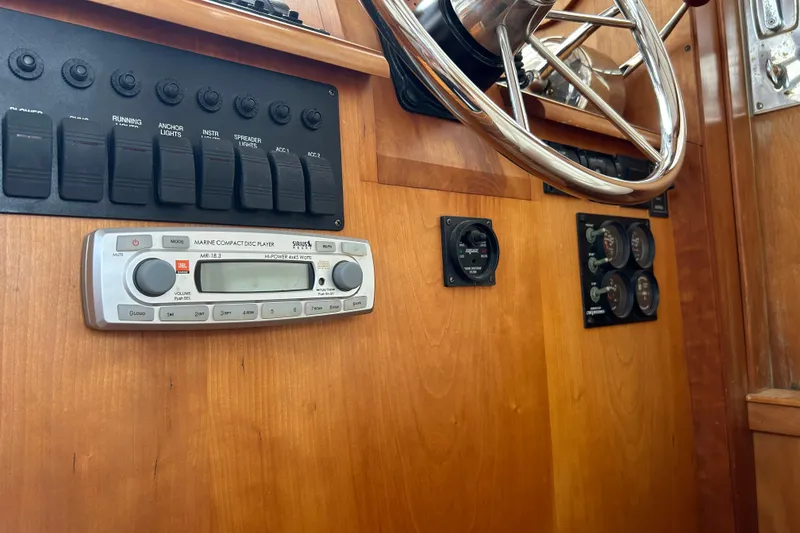 Slide: The Image of 2004 Sabre 36 FB boat dashboard with steering wheel, controls, and marine CD player. - 18