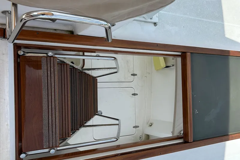 Slide: The Image of Staircase leading below deck on 2004 Sabre 36 FB yacht, featuring wooden and metal design. - 7
