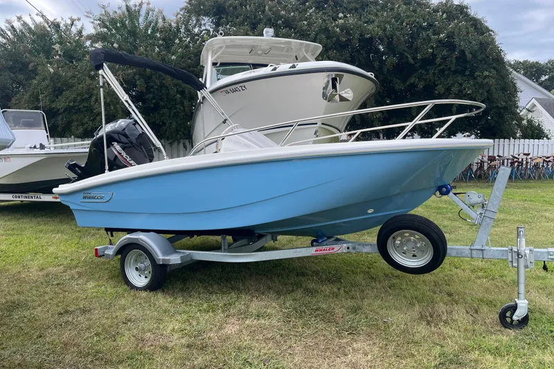 Slide: The Image of 2026 Boston Whaler 130 Super Sport boat on trailer, displayed outdoors. - 0