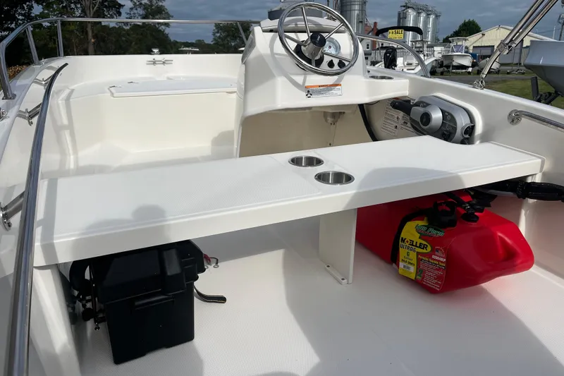 Slide: The Image of 2026 Boston Whaler 130 Super Sport interior with steering wheel and storage compartments. - 11